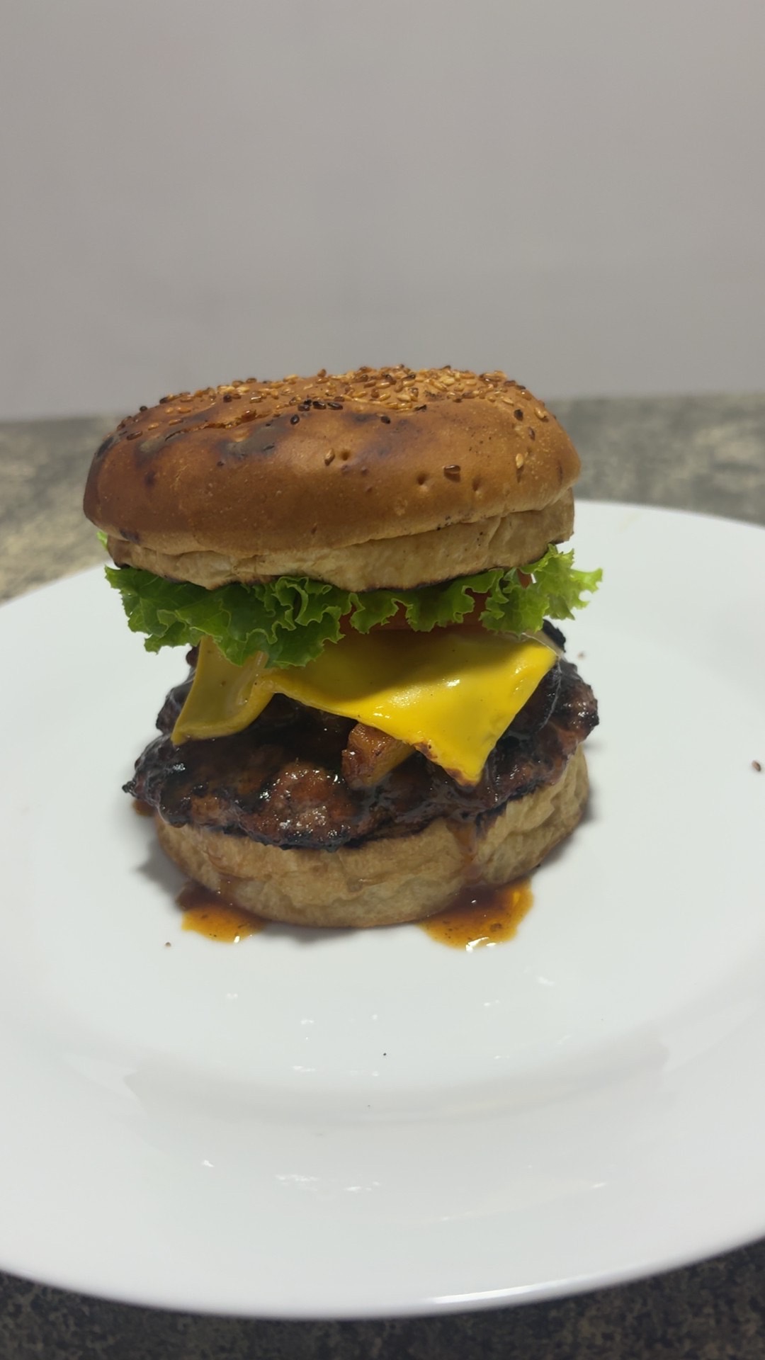 Hamburguesa con queso derretido, lechuga y pan de sésamo